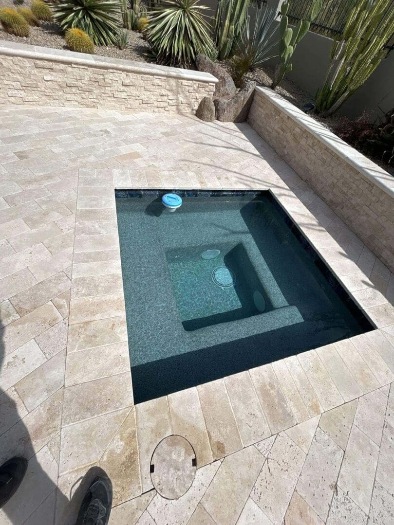 A pool with a glass bottom and stone wall.